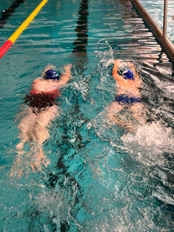 dzieci płyną na brzuchu, ćwicząc ruchy ramion w kraulu